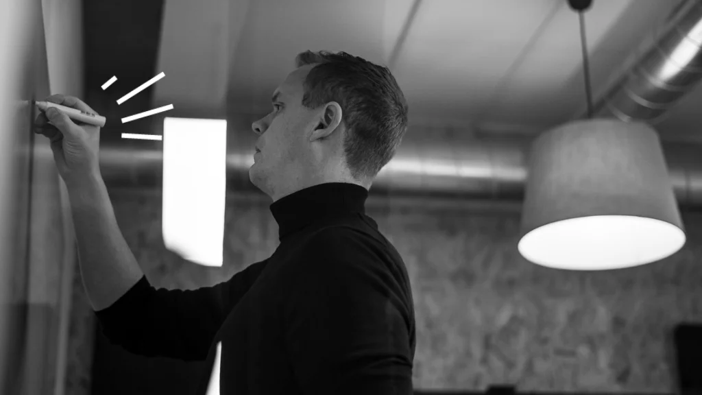 Tall scandinavian man writing on a whiteboard in a conference room