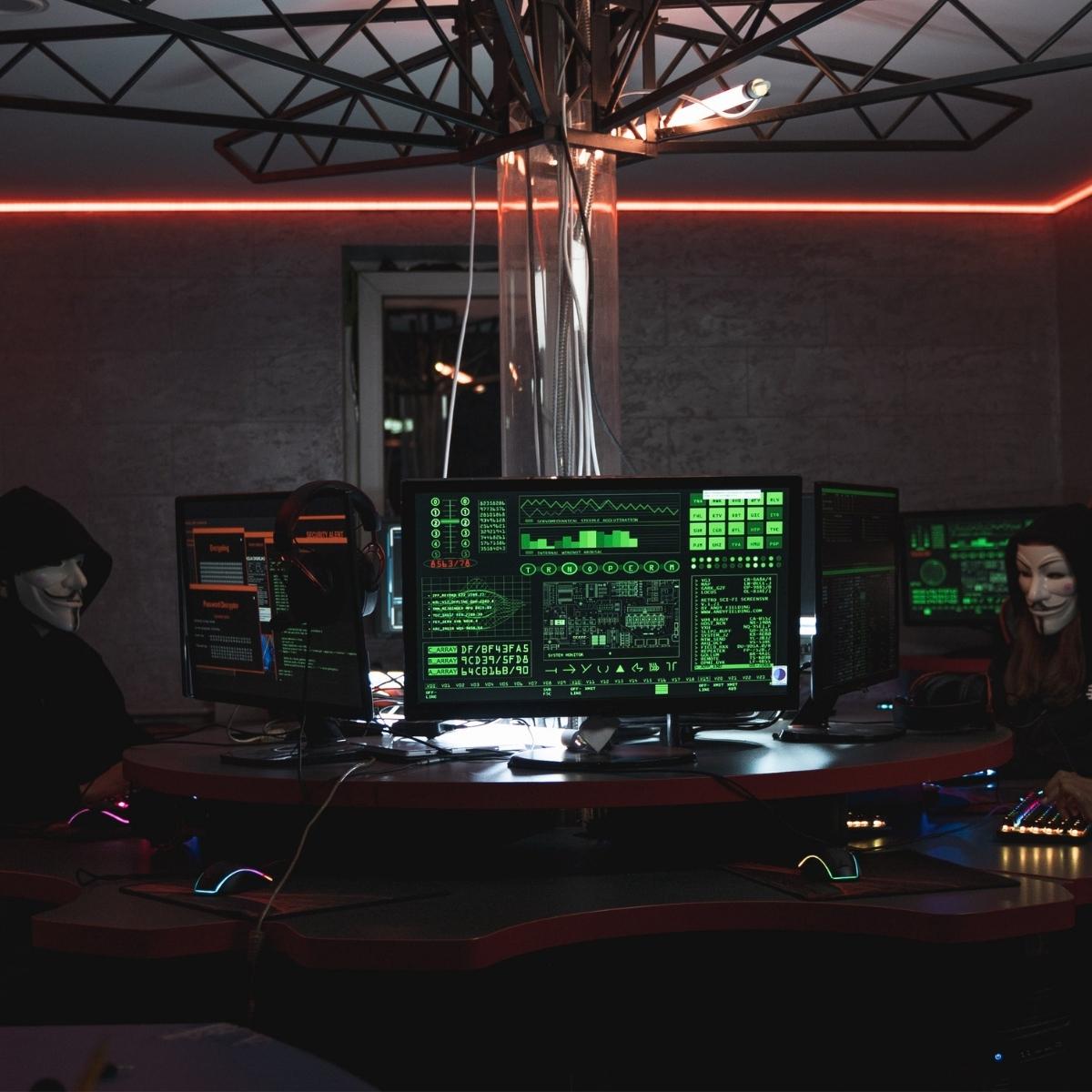 Hackers in a dark room in front of computers